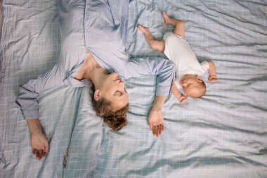 Anne ve yeni doğan yatak odasında birlikte yatıyorlar. Ortak uyku konsepti. Yorgun ebeveyn. Doğal ebeveynlik bakımı. Sessizlik sakindir. Annelik bebek birlikteliği. Gerçek hayat tarzı.