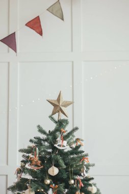 Noel ağacı dalının en iyi yıldızı. Noel kartpostalı. Yeni yıl beyaz arka plan sınırı. Boşluğu metin için kopyala. Geçmişe dönük nostalji eğilimi. Kış aralığı. Sıcak İskandinav kucaklaşması