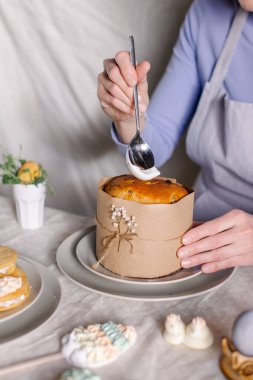 Paskalya pastasını mutfak süsleri ve şekerlerle süsleme süreci. Servis masasına yakın plan kek. Bayram ziyafeti bir Hristiyan bahar geleneğidir. İsa dirildi. iş şekerlemeci