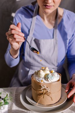 Paskalya pastasını mutfak süsleri ve şekerlerle süsleme süreci. Servis masasına yakın plan kek. Bayram ziyafeti bir Hristiyan bahar geleneğidir. İsa dirildi. iş şekerlemeci