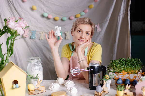 A positive culinary specialist makes meringues. Marshmallow cooking process. Easter festive dinner table. Womens day mother in the kitchen at home. Small business confectionery chef. Funny sweets