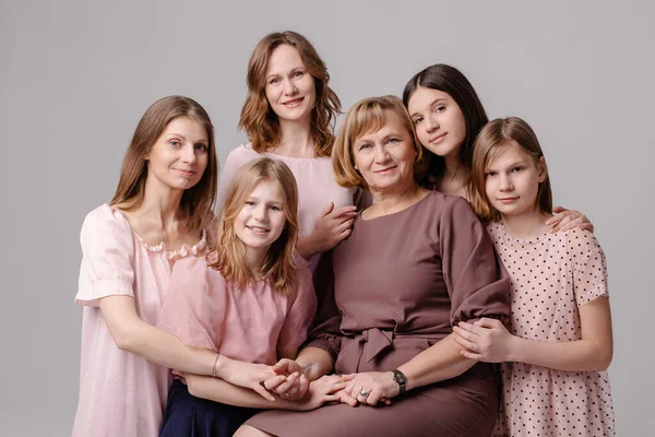 Woman\'s wife 8 march concept. Large family of women of different ages hugging portrait. Femininity support caring. Several female generations. Maternity is sisterhood feminism. Grandmother