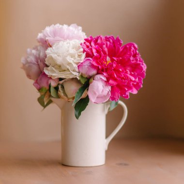 Ahşap bir arka planda vazodaki şakayık demeti