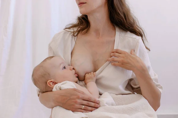 mother is breastfeeding her baby. Woman in white and child on her arms. Kid sucks breast milk. Holy motherhood. Caring tenderness protection. Mother love concept. Heart shaped veins. Natural nutrition