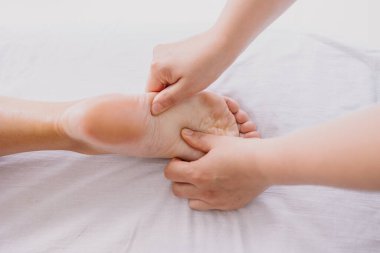 Ayak masajı yakın plan. Spa salonu kendi kendine bakım rahatlaması. Ayakları büküyorum. Zevkli zevkler. - Masör çalışıyor. Yorgunluk ve bacak ağrısını tedavi ediyor. Sağlık hizmeti akupunkturu. Masaj Topuğu Parmaklar ayak
