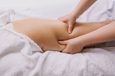 Kadın spa salonunda anti-selülit masajı yaptırıyor.
