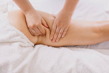 Kadın spa salonunda anti-selülit masajı yaptırıyor.