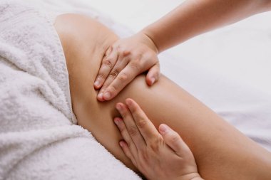 Kadın spa salonunda anti-selülit masajı yaptırıyor.
