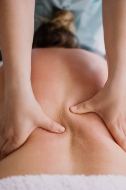 Kadın sırt masajında yatıyor. Kas ağrısını tedavi ediyorum. Masör müşteriyi yoğurur. İşte kayropraktik uzmanı. Osteopat masajı. Rahatlama terapisi. Omuzlar ve sırt bakımı. Kaplıcadaki hasta.