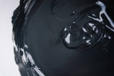 Kara kil dokusu. Yüze ve vücuda çamur maskesi. Doğal spa tedavisi. Siyah-beyaz stil arka plan. Kozmetoloji cilt tedavisi