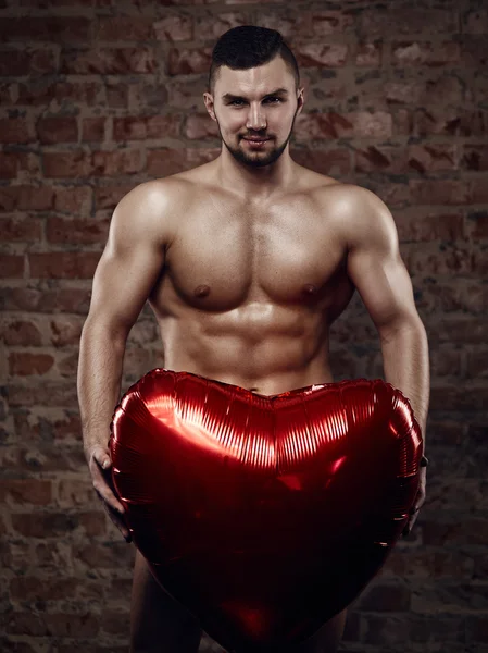 Young muscular man with heart — Stock Photo, Image
