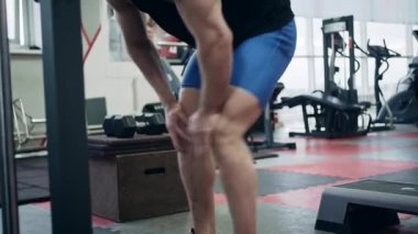 Spor salonundaki genç kaldırıcı, tren için ısınıyor, yavaş çekim.