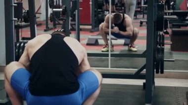 Spor salonundaki genç kaldırıcı, tren için ısınıyor, yavaş çekim.