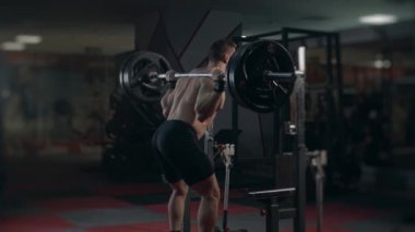 Jimnastik salonundaki genç kaldırıcı bileşik hareketler yapıyor. Çömel. Yavaş çekim