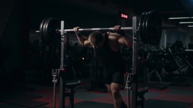 Jimnastik salonundaki genç kaldırıcı bileşik hareketler yapıyor. Çömelmeye hazırlanıyorum. Yavaş çekim