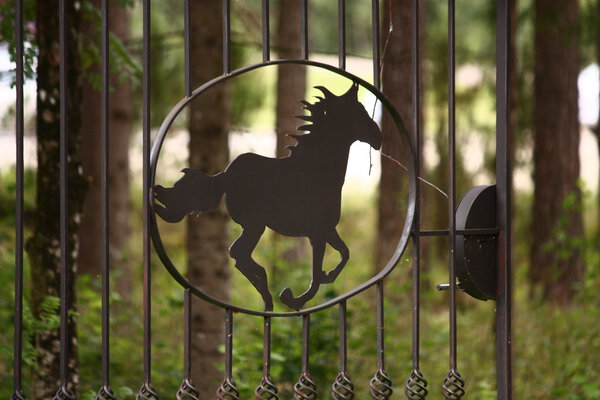 Металлический забор в форме скачущей лошади
