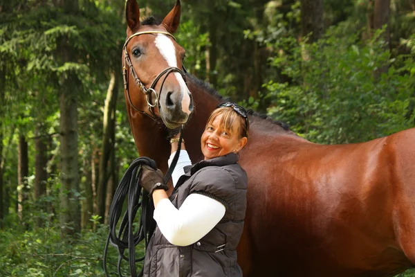 Mujer mayor y retrato de caballo marrón en el bosque — Foto de Stock