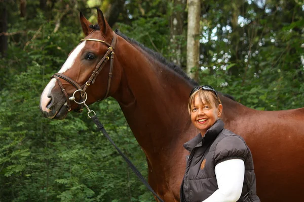 Starsza kobieta i brązowy koń portret w lesie — Zdjęcie stockowe