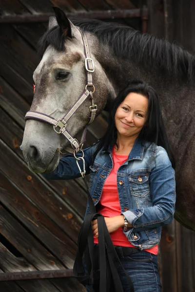 Güzel bir genç kadın ve gri atı portre — Stok fotoğraf