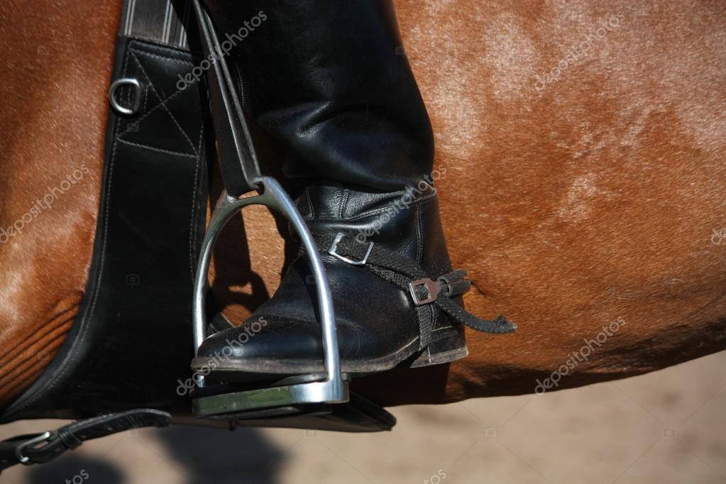 Close up of rider leg with spur in stirrup — Stock Photo © virgonira