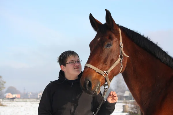 Adolescent garçon et baie cheval portrait en hiver — Photo