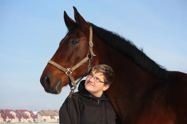 Teenager boy and bay horse portrait in winter — Stock Photo, Image