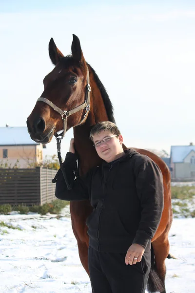 Teenager boy and bay horse portrait in winter — Stock Photo, Image