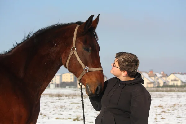 Teenager boy and bay horse portrait in winter — Stock Photo, Image