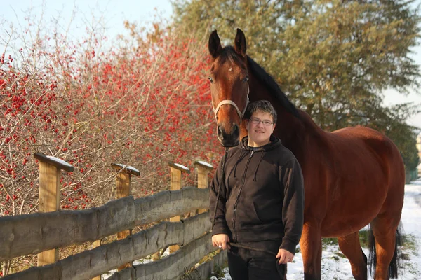 Plump happy teenager boy and brown horse portrait — Stock Photo, Image