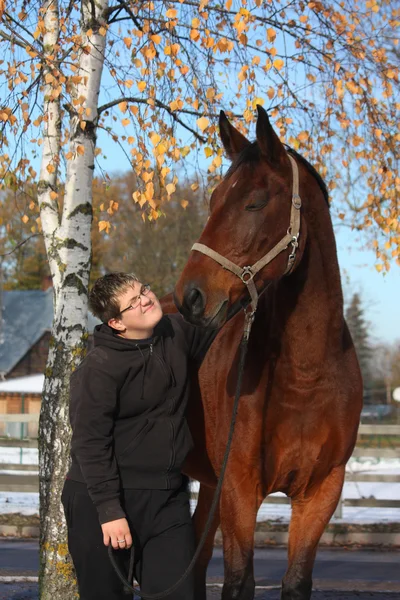 Teenager boy and brown horse portrait in autumn — Stock Photo, Image