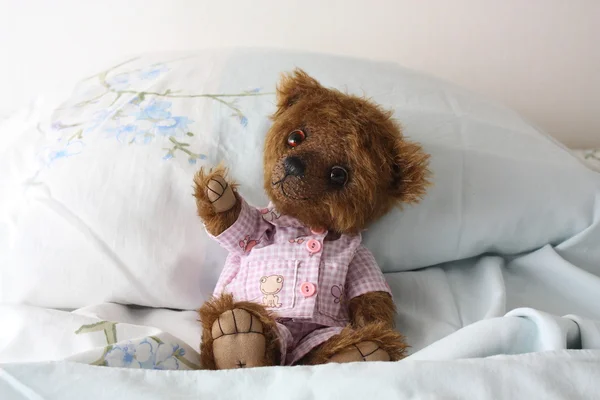 Милый бурый плюшевый мишка в пижаме в постели — стоковое фото