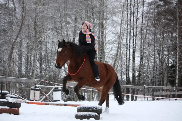 Teenager girl with brown horse show jumping without bridle and s — Stock Photo, Image