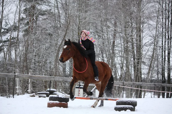 Teenager girl with brown horse show jumping without bridle and s — Stock Photo, Image