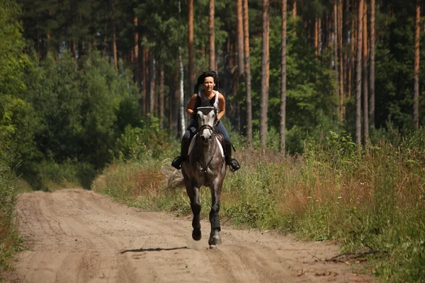 Hermosa mujer montando caballo gris en el bosque —  Fotos de Stock