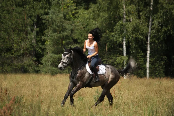 Mulher bonita montando cavalo cinza na floresta — Fotografia de Stock