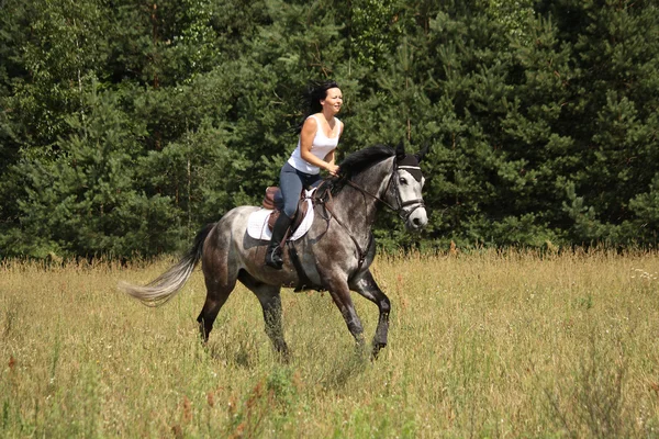 Hermosa mujer montando caballo gris en el bosque —  Fotos de Stock