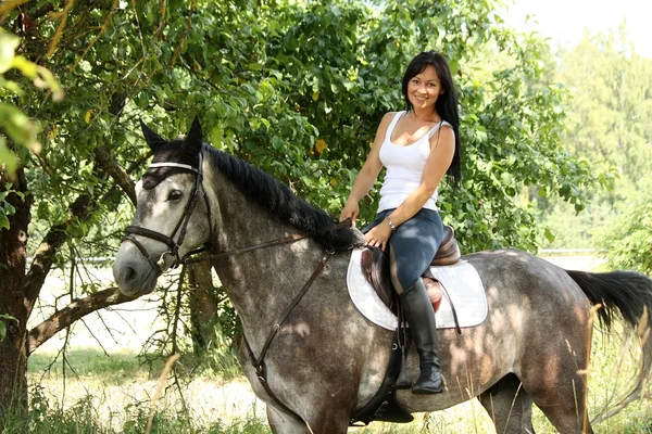 Portrait of beautiful woman and gray horse in garden — Stock Photo, Image