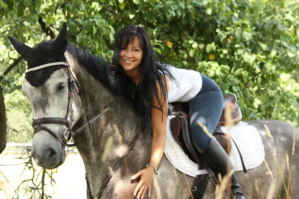 Ritratto di bella donna e cavallo grigio in giardino — Foto Stock