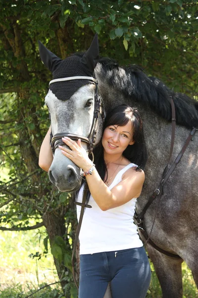 Portrait of beautiful woman and gray horse in garden — Stock Photo, Image