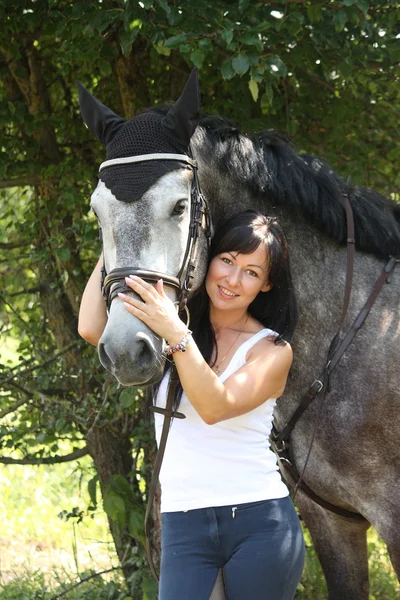 Ritratto di bella donna e cavallo grigio in giardino — Foto Stock