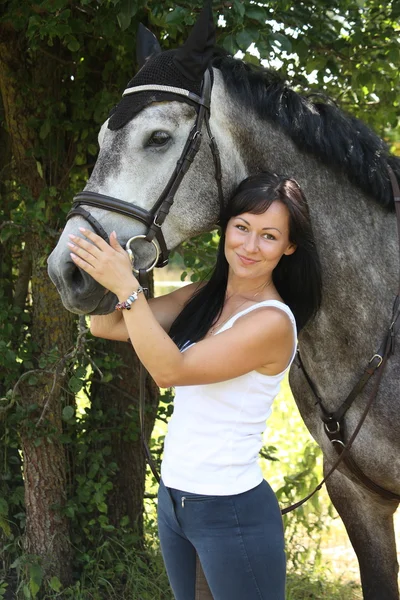 Ritratto di bella donna e cavallo grigio in giardino — Foto Stock