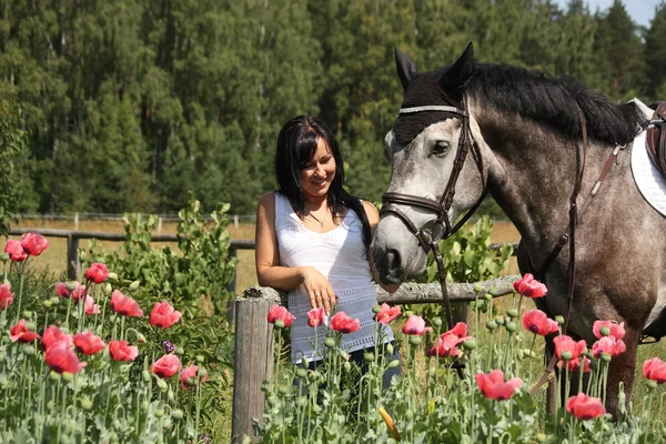 Beautiful woman in the blooming garden with horse — Stock Photo, Image