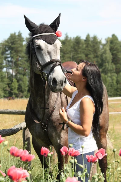 Beautiful woman in the blooming garden with horse — Stock Photo, Image