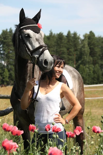 Mulher bonita no jardim florescente com cavalo — Fotografia de Stock