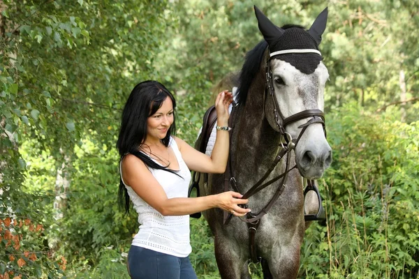 Piękna kobieta i szary konia portret w ogrodzie — Zdjęcie stockowe