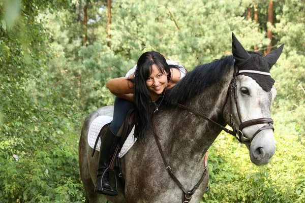 Piękna kobieta i szary konia portret w ogrodzie — Zdjęcie stockowe