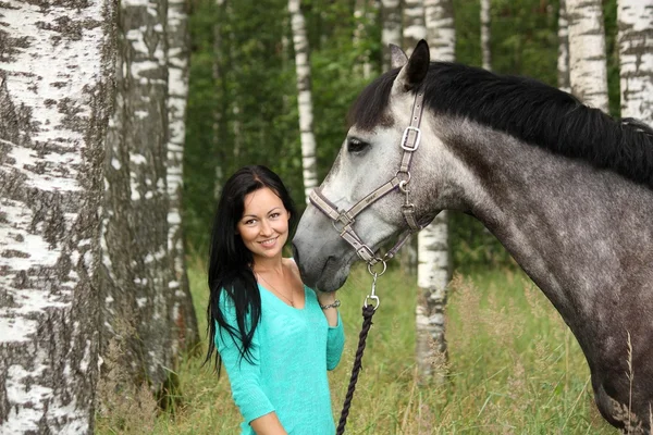 Красивая молодая женщина и портрет серой лошади — стоковое фото