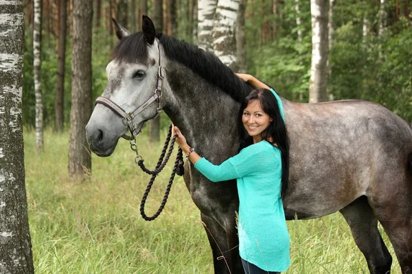 Красивая молодая женщина и портрет серой лошади — стоковое фото