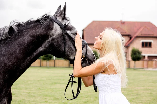 Portret van mooie blonde vrouw en grijze paard op de bruiloft — Stockfoto