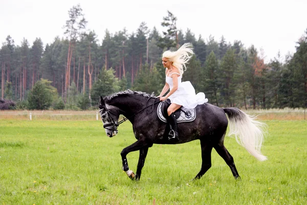 Beautiful blonde woman and gray horse riding — Stock Photo, Image